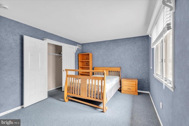 bedroom with a closet, carpet flooring, and baseboards