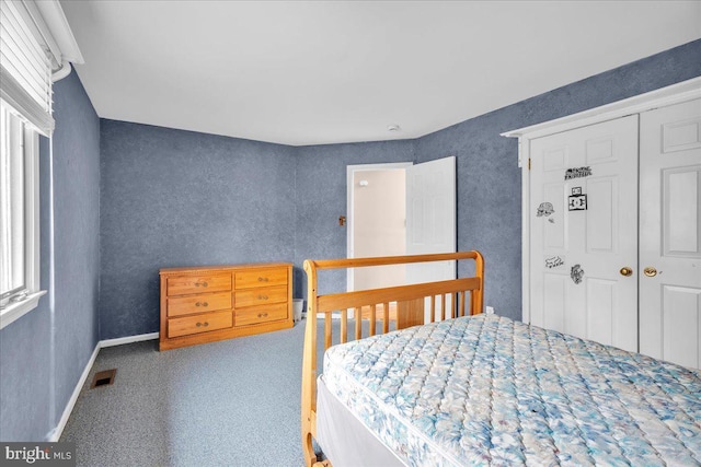 bedroom featuring carpet floors, a closet, visible vents, multiple windows, and baseboards