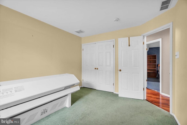 carpeted bedroom featuring a closet, visible vents, and baseboards