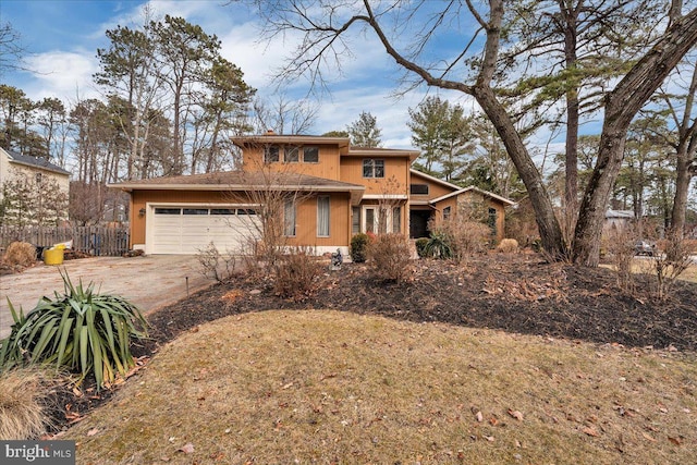 view of front of house with concrete driveway, fence, and an attached garage