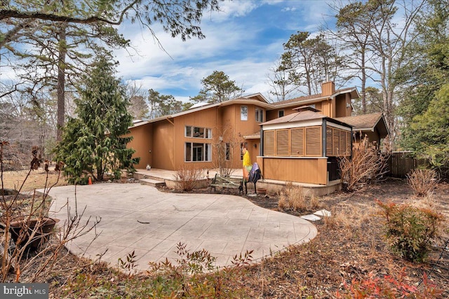 back of house featuring a chimney and a patio area