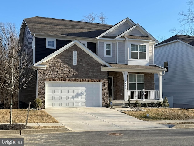 craftsman inspired home with stone siding, a porch, and concrete driveway