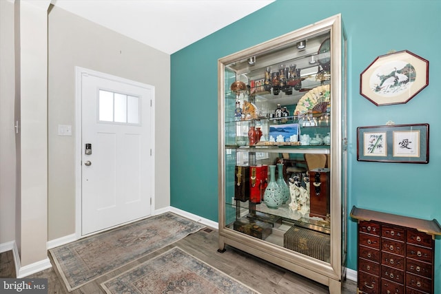 entryway featuring baseboards and wood finished floors