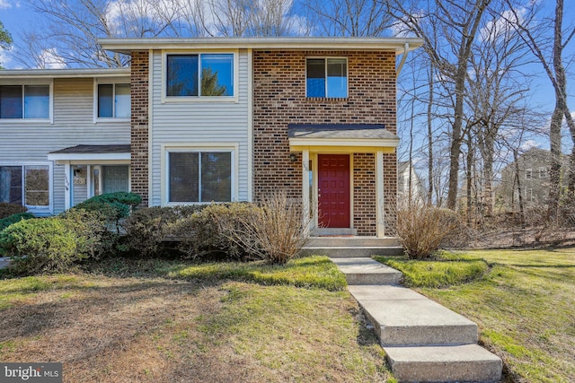 view of front of property featuring brick siding and a front lawn