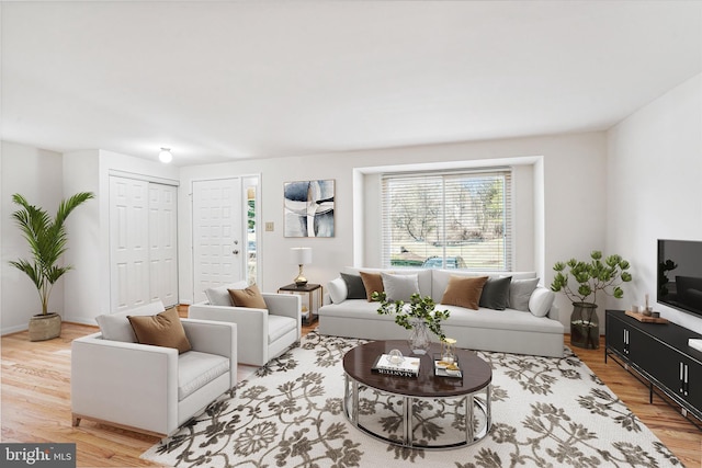 living area with baseboards and wood finished floors