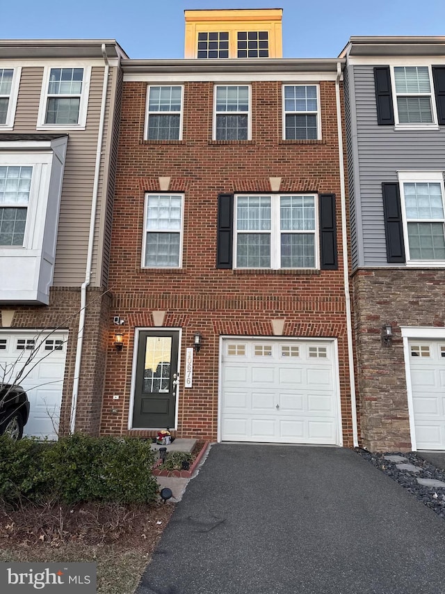 multi unit property featuring brick siding and driveway