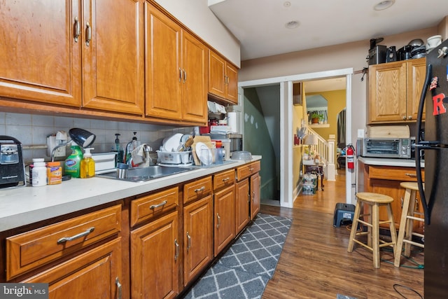 kitchen with brown cabinetry, a sink, and decorative backsplash