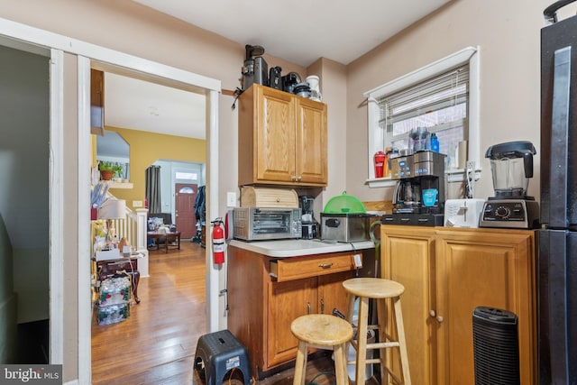 kitchen with a toaster, arched walkways, and wood finished floors