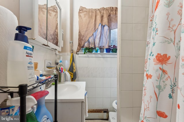 full bath featuring curtained shower, toilet, tile walls, and vanity