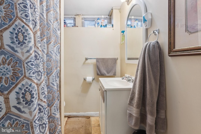 full bath featuring a shower with curtain, tile patterned flooring, vanity, and baseboards