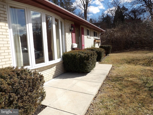 view of side of home with a yard and brick siding