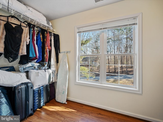 walk in closet with wood finished floors