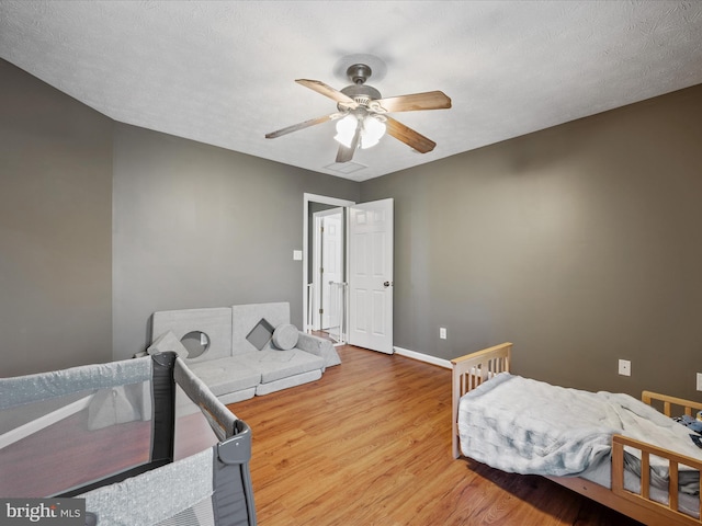 bedroom with a ceiling fan, baseboards, and wood finished floors