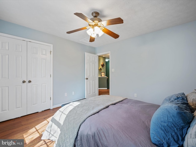 bedroom featuring a closet, a ceiling fan, and wood finished floors