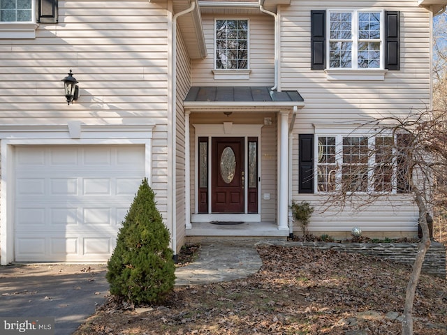 entrance to property featuring metal roof, a standing seam roof, and an attached garage