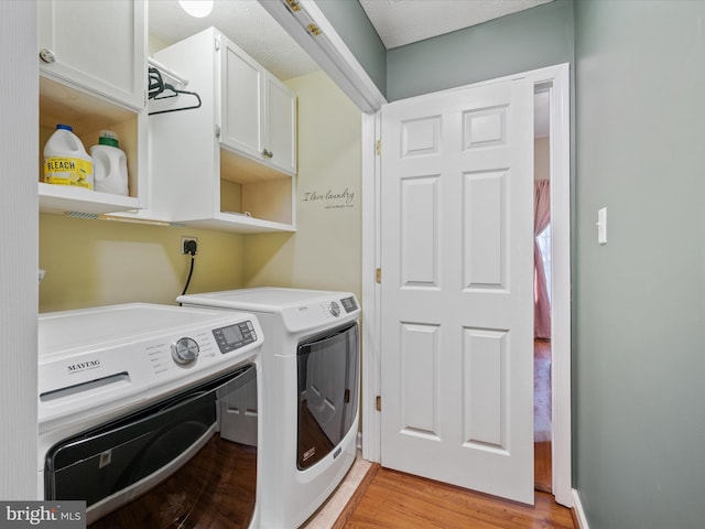 washroom with cabinet space, light wood-style floors, and independent washer and dryer