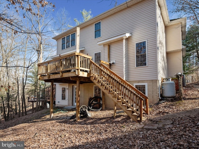 rear view of property with a wooden deck and stairs