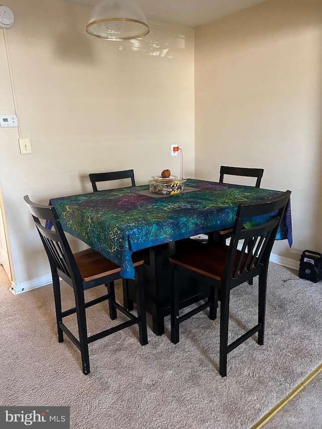 dining area featuring carpet floors and baseboards