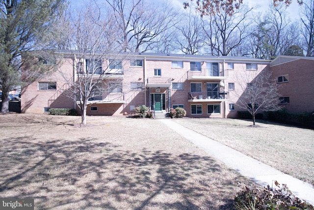 view of front of property featuring a balcony and brick siding