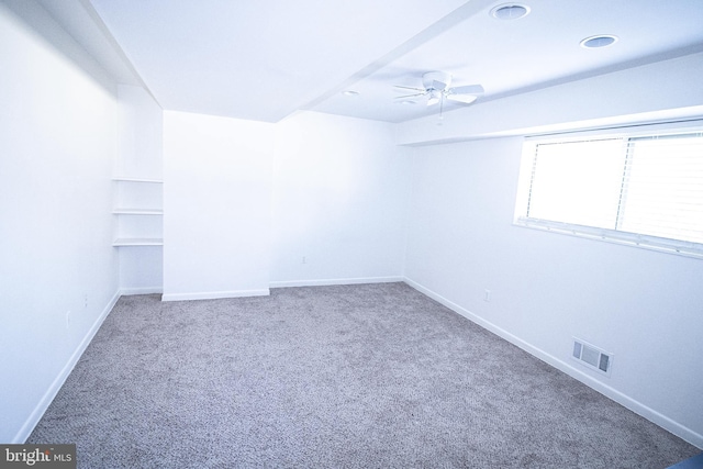 carpeted empty room with visible vents, baseboards, and a ceiling fan