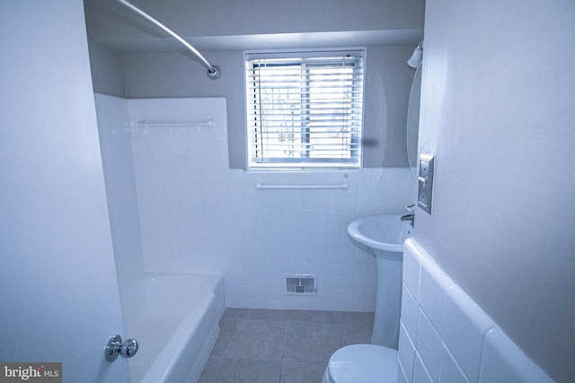 full bath with visible vents, tile patterned flooring, tile walls, toilet, and shower / bathtub combination