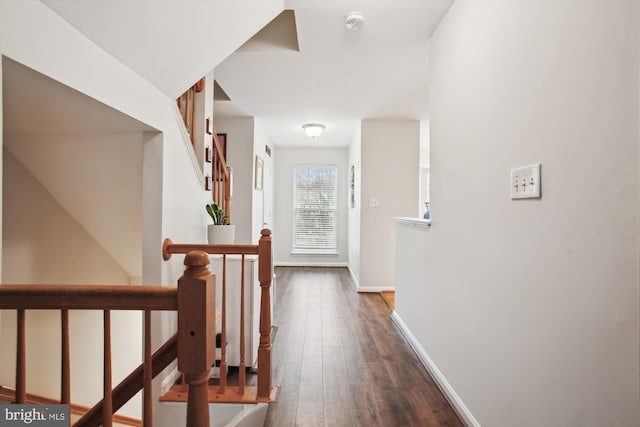 corridor with dark wood finished floors and baseboards