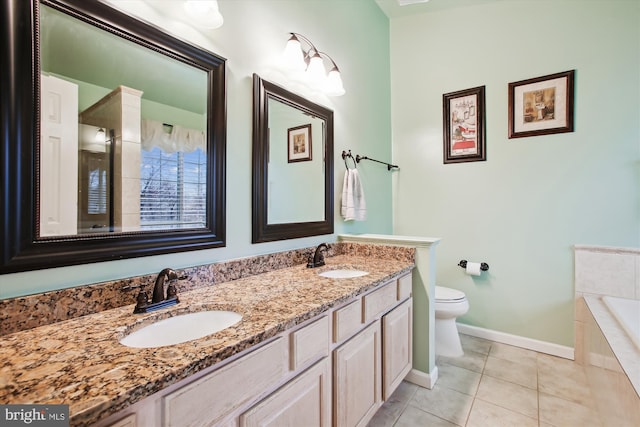 bathroom with tiled bath, tile patterned flooring, a sink, and double vanity