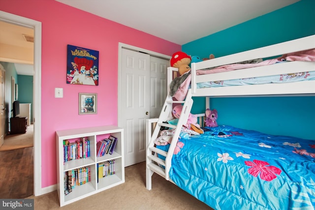 carpeted bedroom with a closet, visible vents, and baseboards