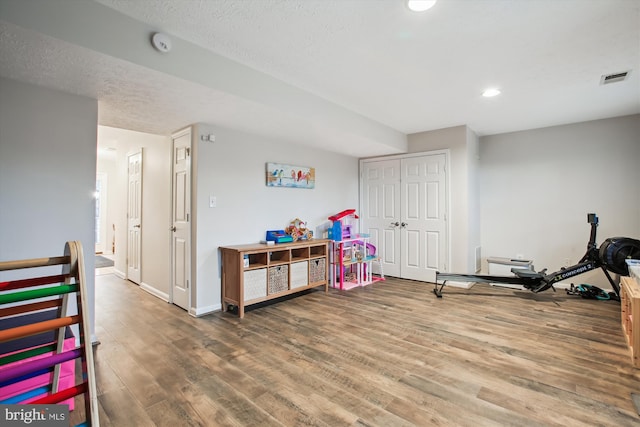 game room with baseboards, visible vents, wood finished floors, a textured ceiling, and recessed lighting