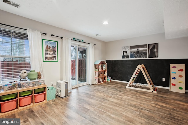 recreation room featuring visible vents, baseboards, and wood finished floors