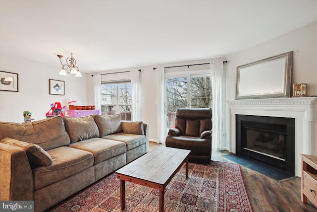 living area with baseboards, dark wood-type flooring, a fireplace with flush hearth, and an inviting chandelier