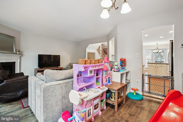 recreation room featuring recessed lighting, a fireplace, a notable chandelier, and wood finished floors