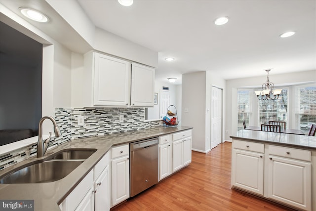 kitchen with white cabinets, dishwasher, light wood-style flooring, backsplash, and a sink