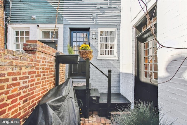 entrance to property featuring brick siding