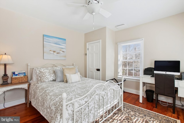 bedroom featuring baseboards, wood finished floors, and a ceiling fan