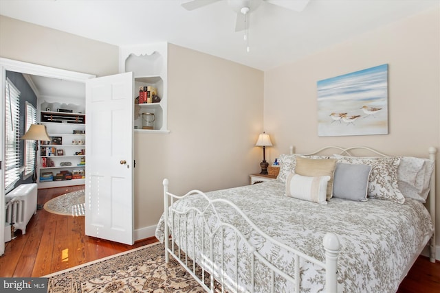 bedroom with baseboards, radiator, wood finished floors, and a ceiling fan