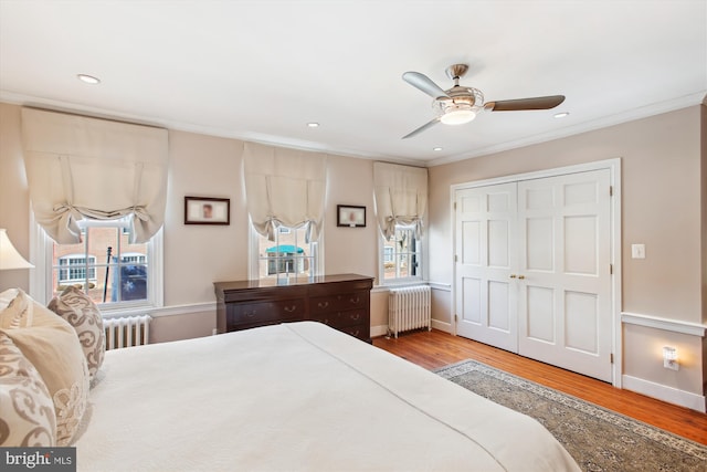 bedroom with radiator, wood finished floors, and crown molding