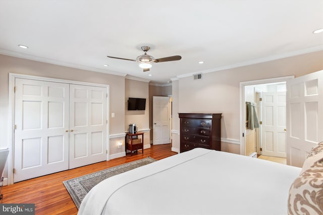 bedroom with visible vents, ornamental molding, recessed lighting, wood finished floors, and a closet