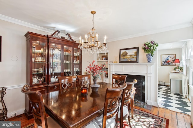 dining room with crown molding, baseboards, wood-type flooring, and a chandelier