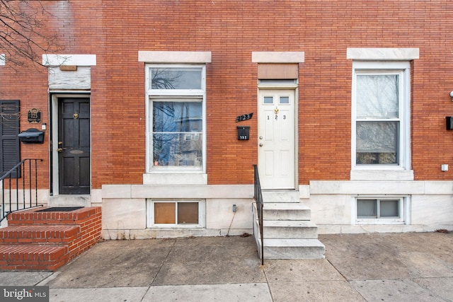 doorway to property with brick siding