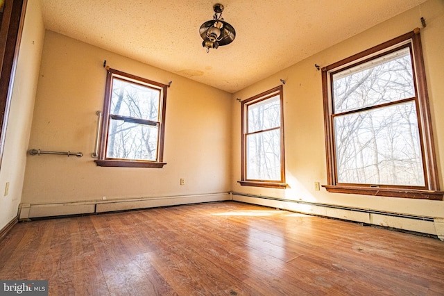 unfurnished room with hardwood / wood-style flooring and a textured ceiling