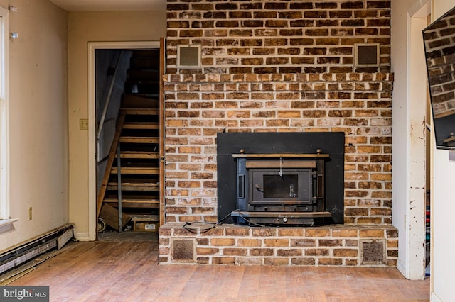 details with a wood stove, visible vents, and wood finished floors