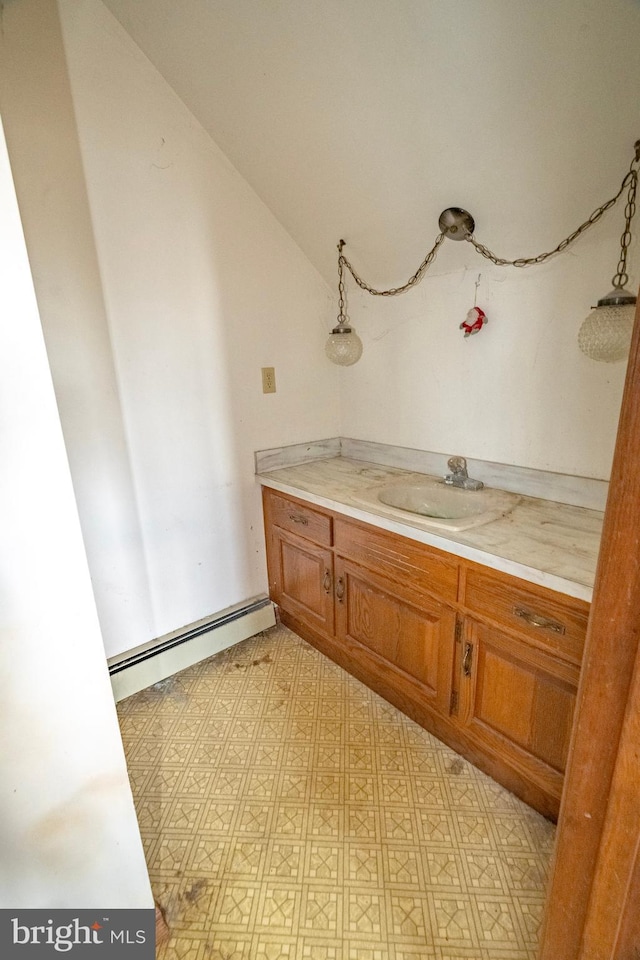 bathroom with lofted ceiling, baseboard heating, vanity, and tile patterned floors