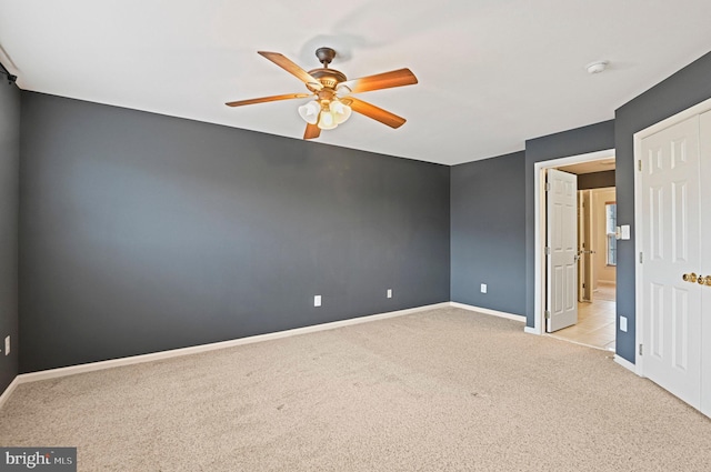 empty room featuring carpet floors, ceiling fan, and baseboards