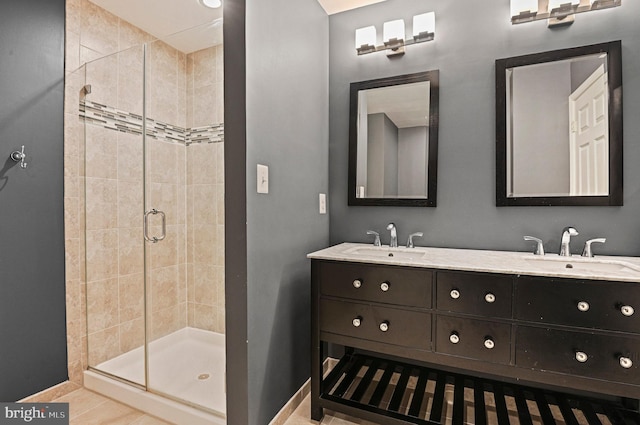 bathroom featuring a stall shower, a sink, and baseboards