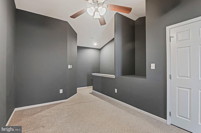 carpeted empty room with a ceiling fan and baseboards