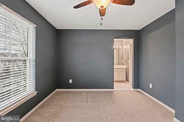 spare room featuring carpet, a healthy amount of sunlight, and baseboards