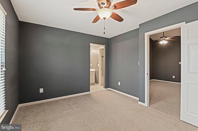 carpeted empty room featuring ceiling fan and baseboards