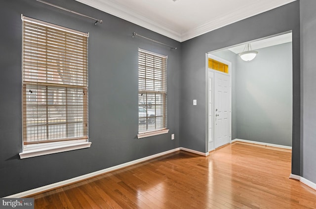 unfurnished room with baseboards, hardwood / wood-style flooring, and crown molding