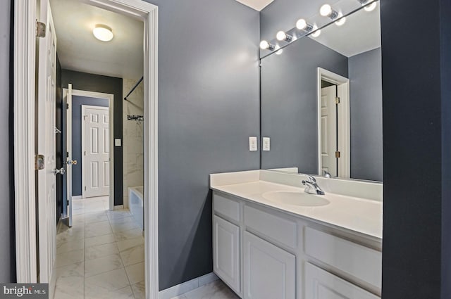 bathroom with marble finish floor, vanity, and baseboards